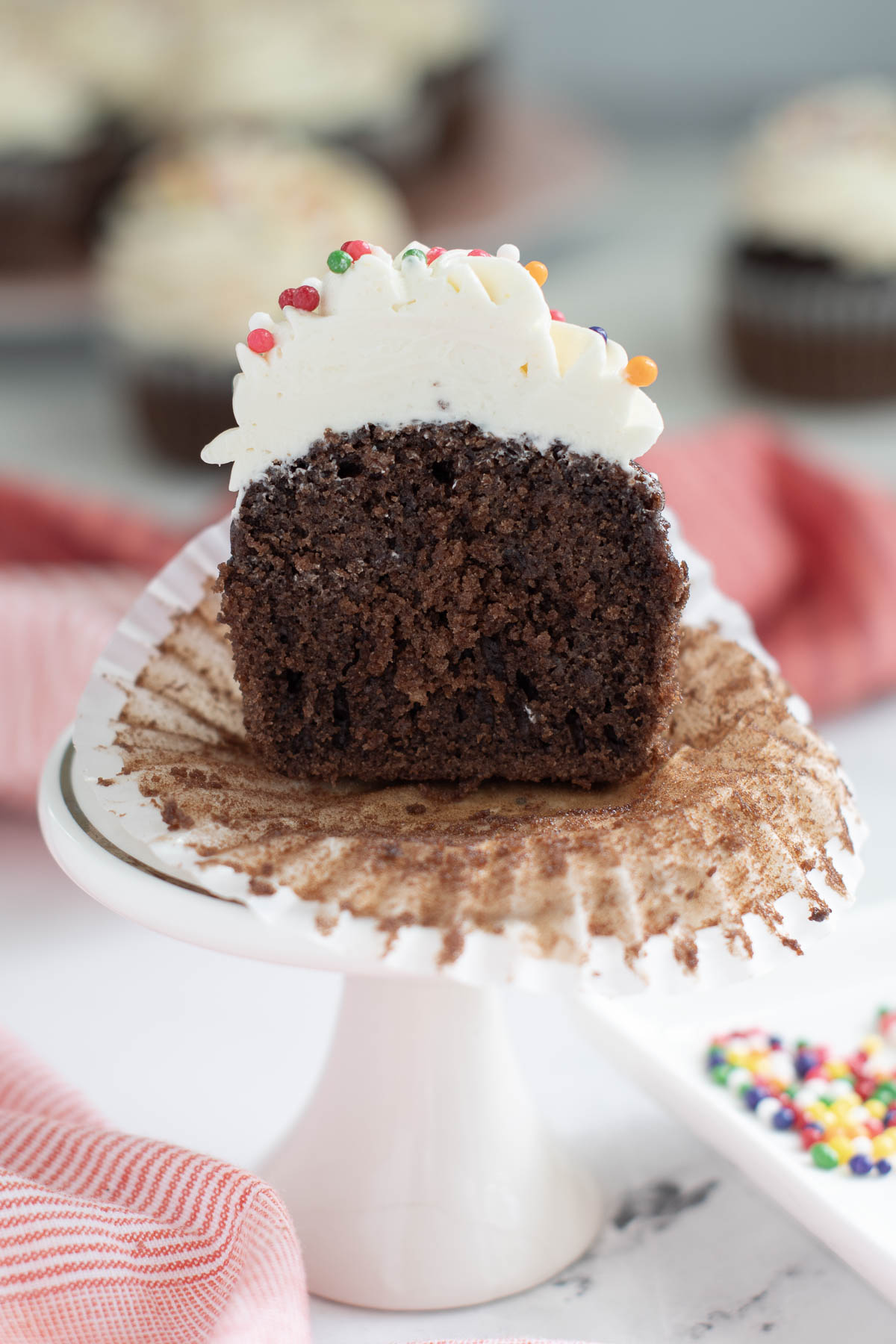 a half a chocolate cupcake with vanilla frosting. 