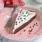 a slice of chocolate pink peppercorn tart on a pink plate.
