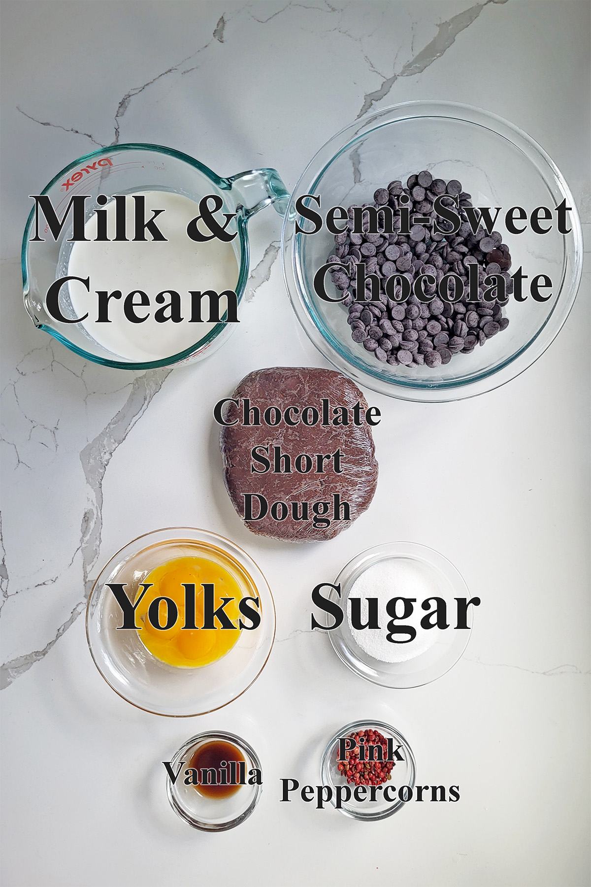 ingredients for chocolate tart with pink peppercorns in glass bowls on a white surface.