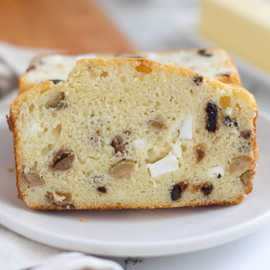 a slice of savory quick bread on a white plate.