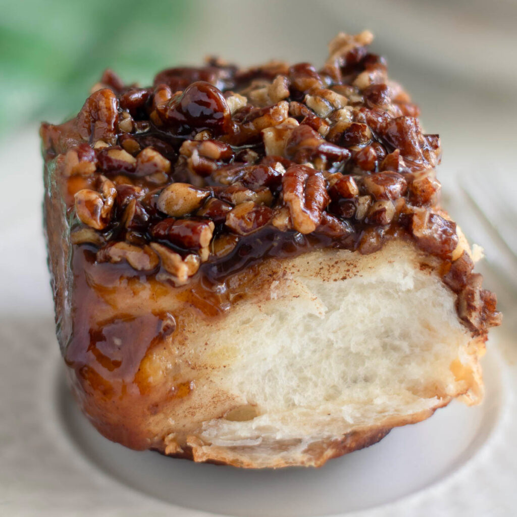 a sourdough sticky bun on a white plate.