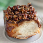 a sourdough sticky bun on a white plate.