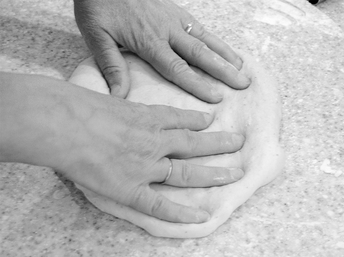 a pair of hand kneading dough.