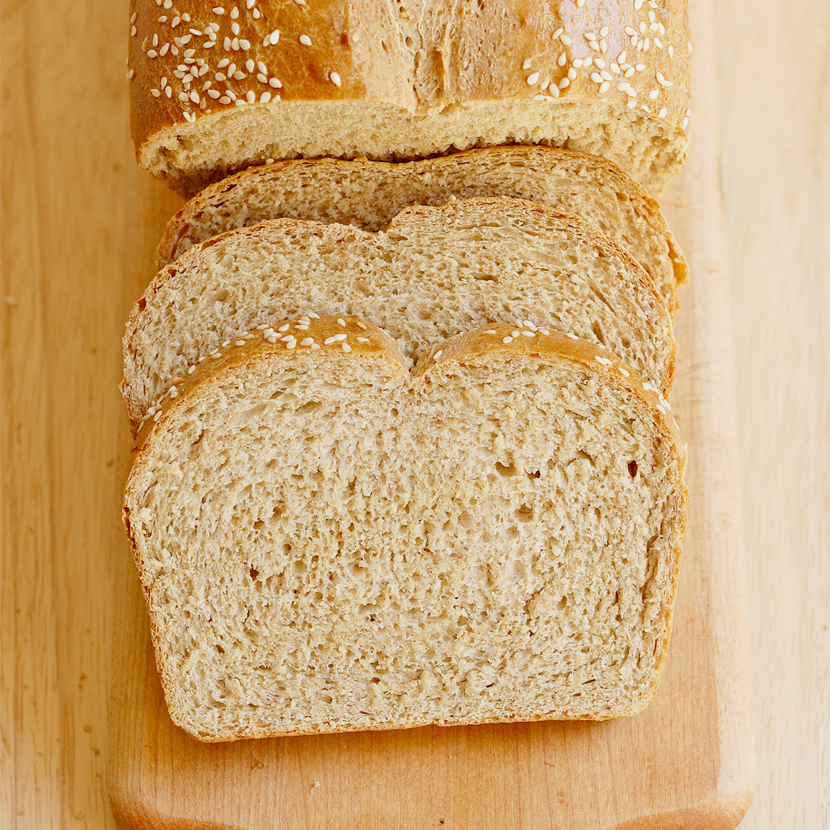 a slice loaf of whole wheat bread on a cutting board.
