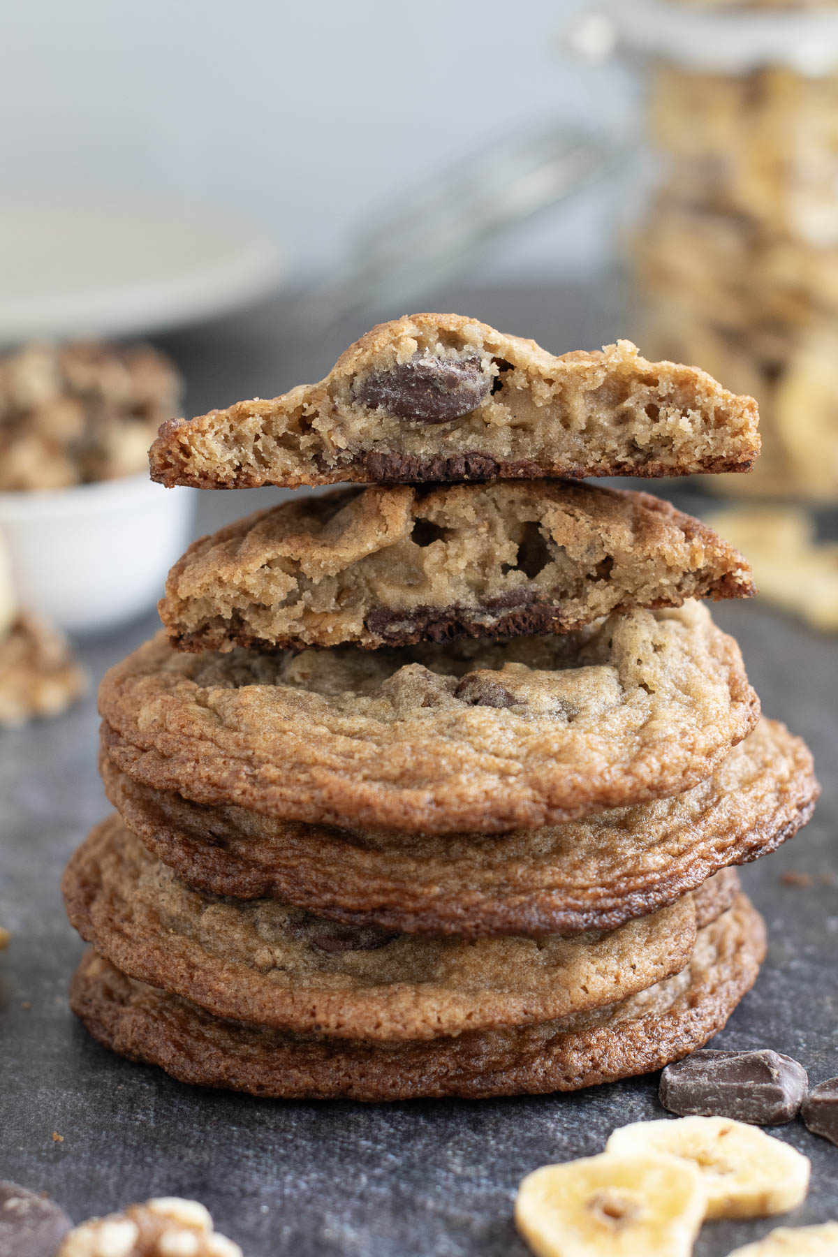 a stack of chocolate chunk banana cookies on a black surface.
