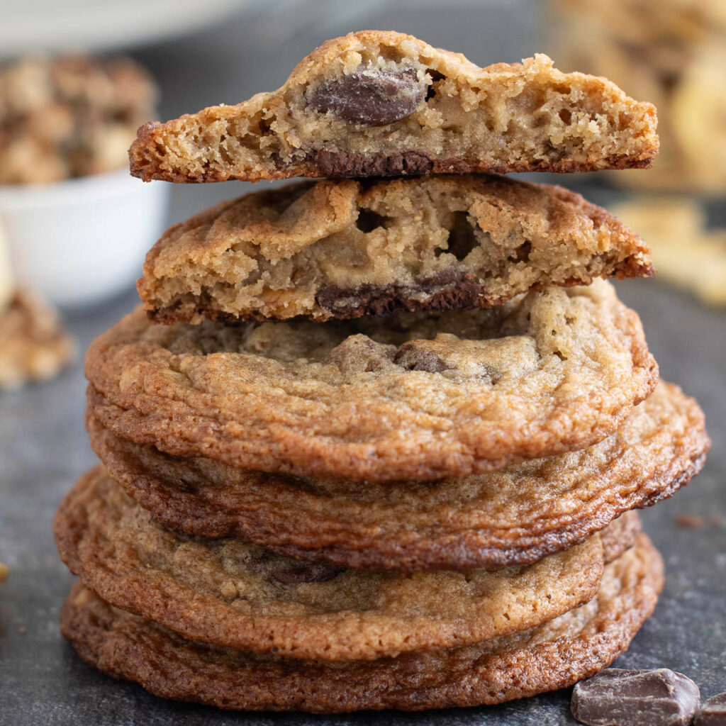 a stack of banana chocolate chunk cookies on a black surface.