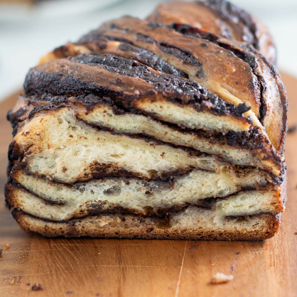 a sliced chocolate babka on a cutting board.