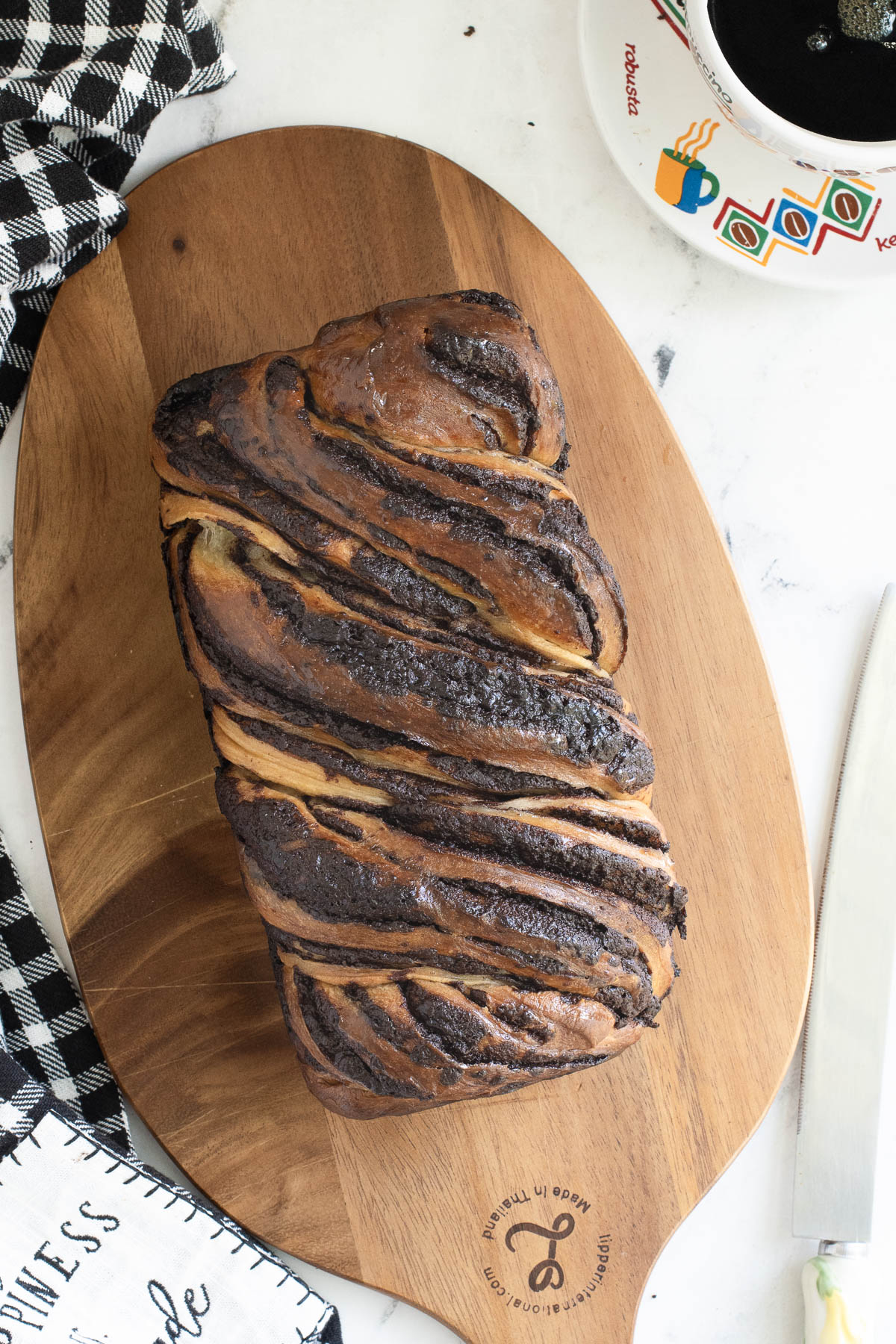 a loaf of sourdough babka on a wooden cutting board.