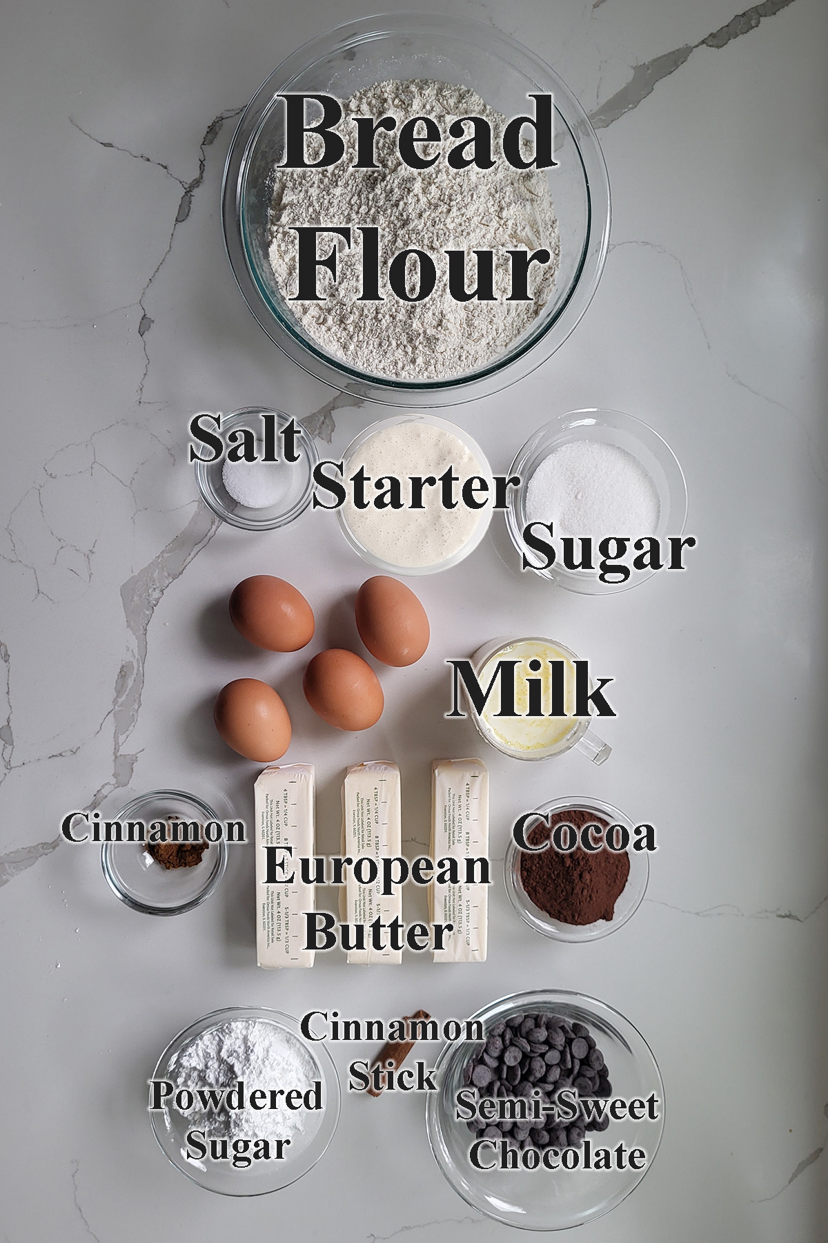 ingredients for sourdough babka in glass bowls on a white surface.