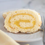 a slice of lemon swiss roll cake on a white plate.