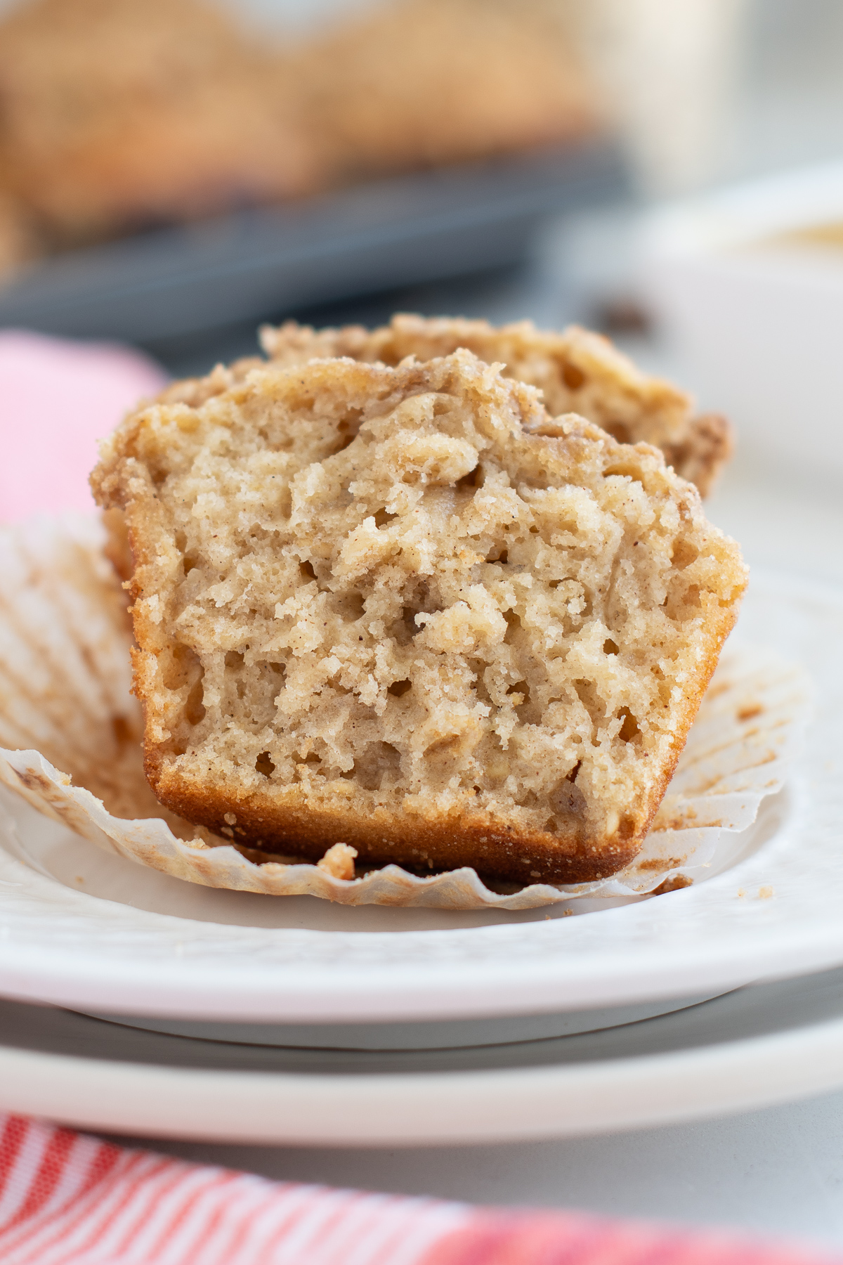 a split applesauce oatmeal muffin on a white plate.