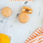a pinterest image for orange macarons with text overlay.
