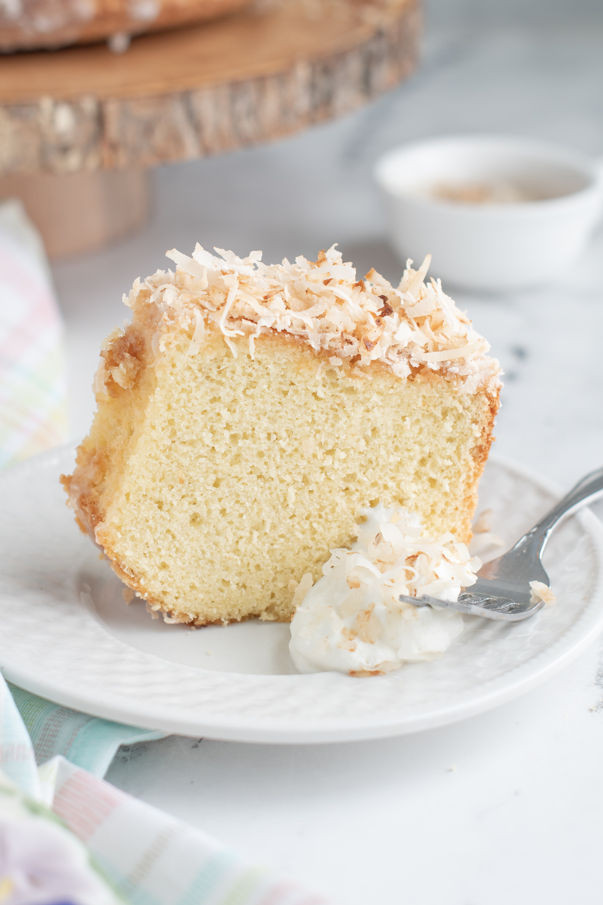 a slice of coconut chiffon cake on a white plate.