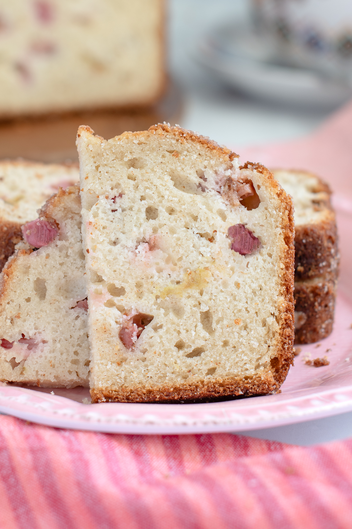 a half slice of rhubarb bread on a pink plate.