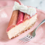 a slice of rhubarb cheesecake on a pink plate.