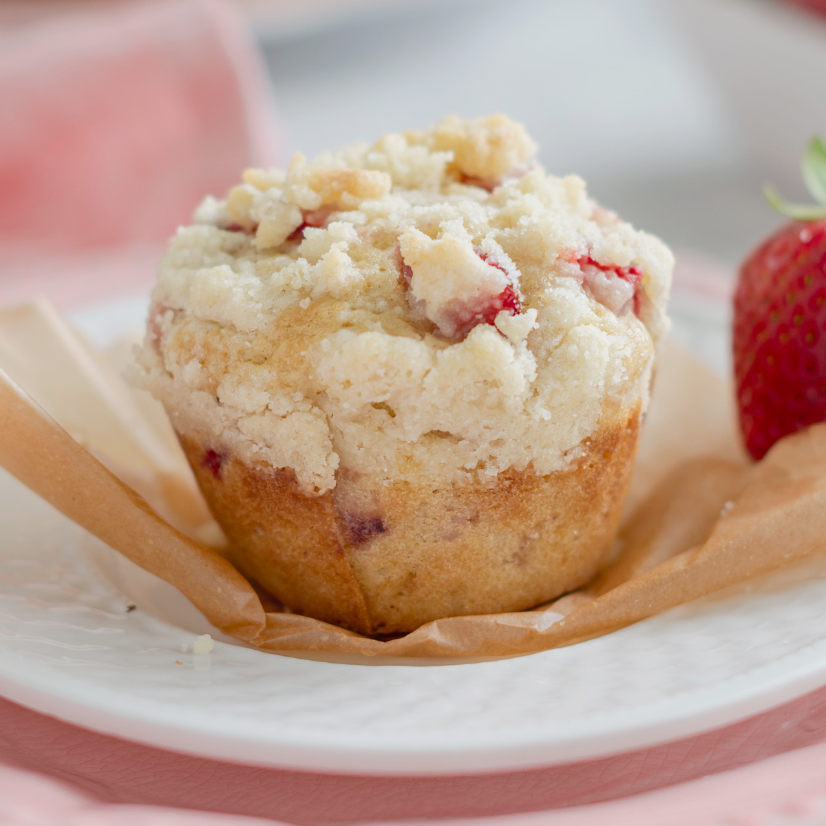 a strawberry muffin on a white plate.