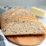 slices of whole grain no knead bread on a cutting board.