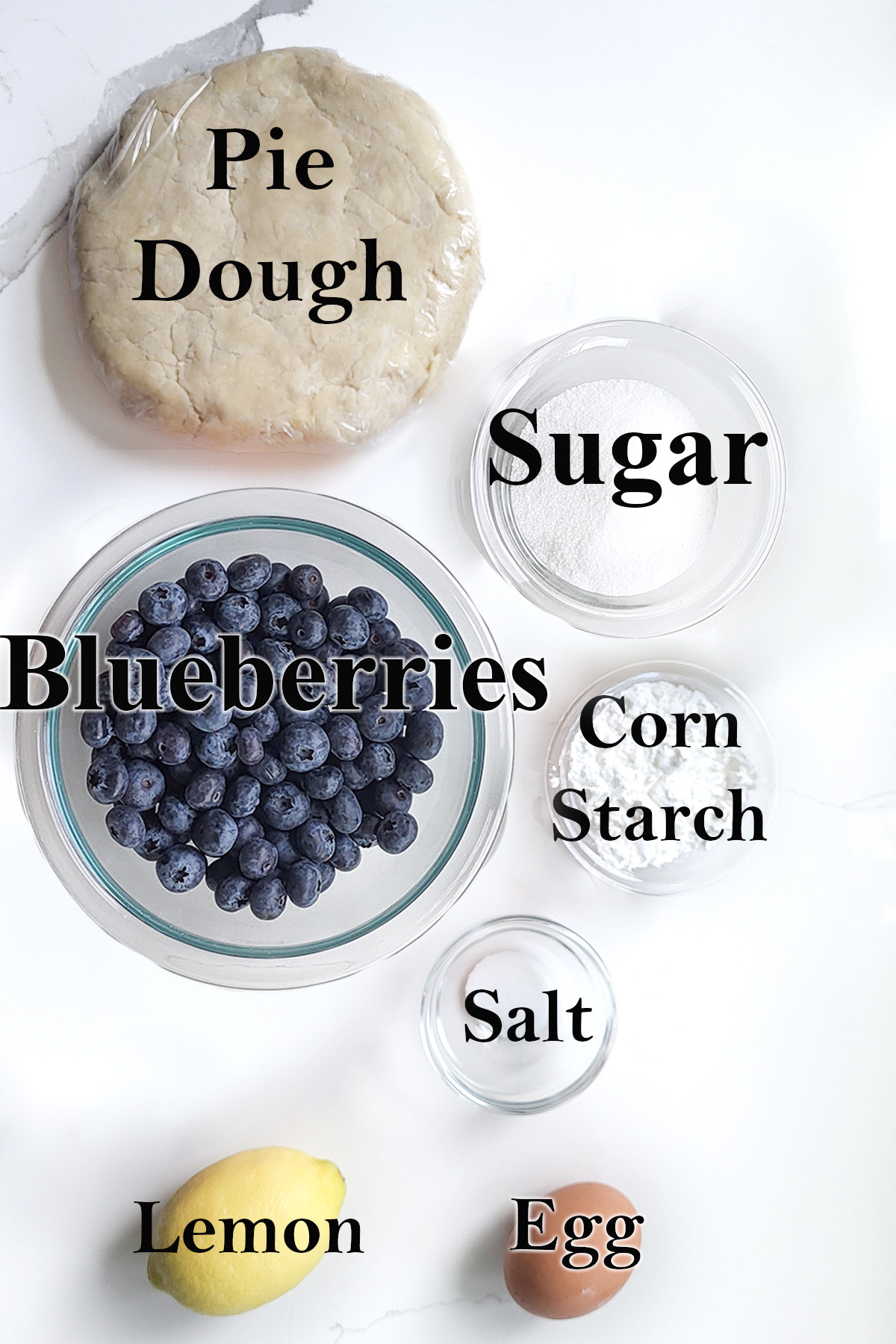ingredients for blueberry pie in glass bowls.
