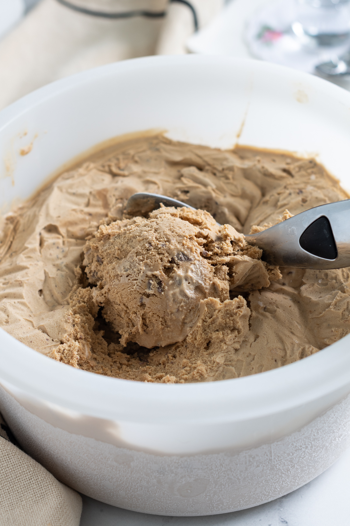 a bucket of homemade coffee ice cream with a scoop in it.