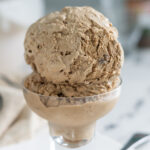 two scoops of coffee ice cream in a glass cup.
