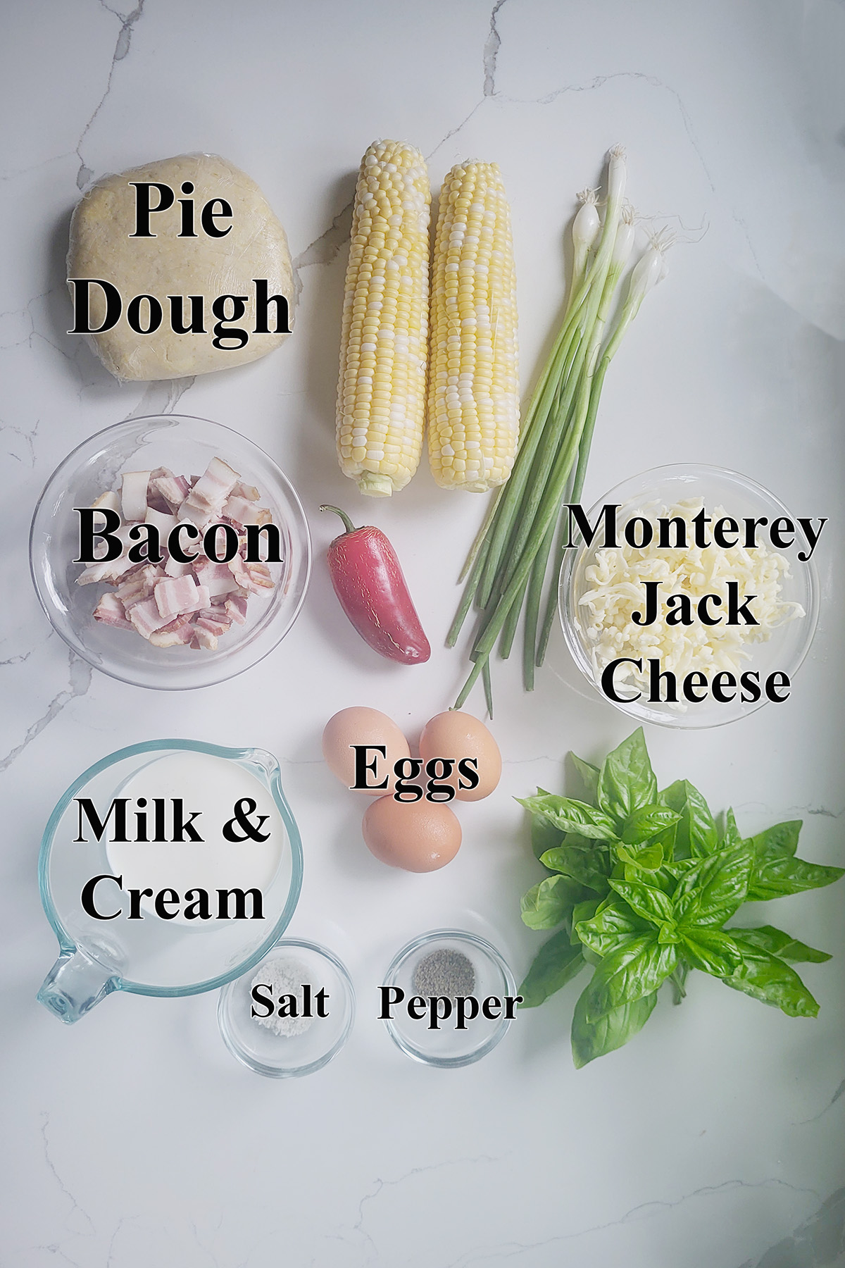 ingredients for corn quiche in glass bowls on a white surface. 