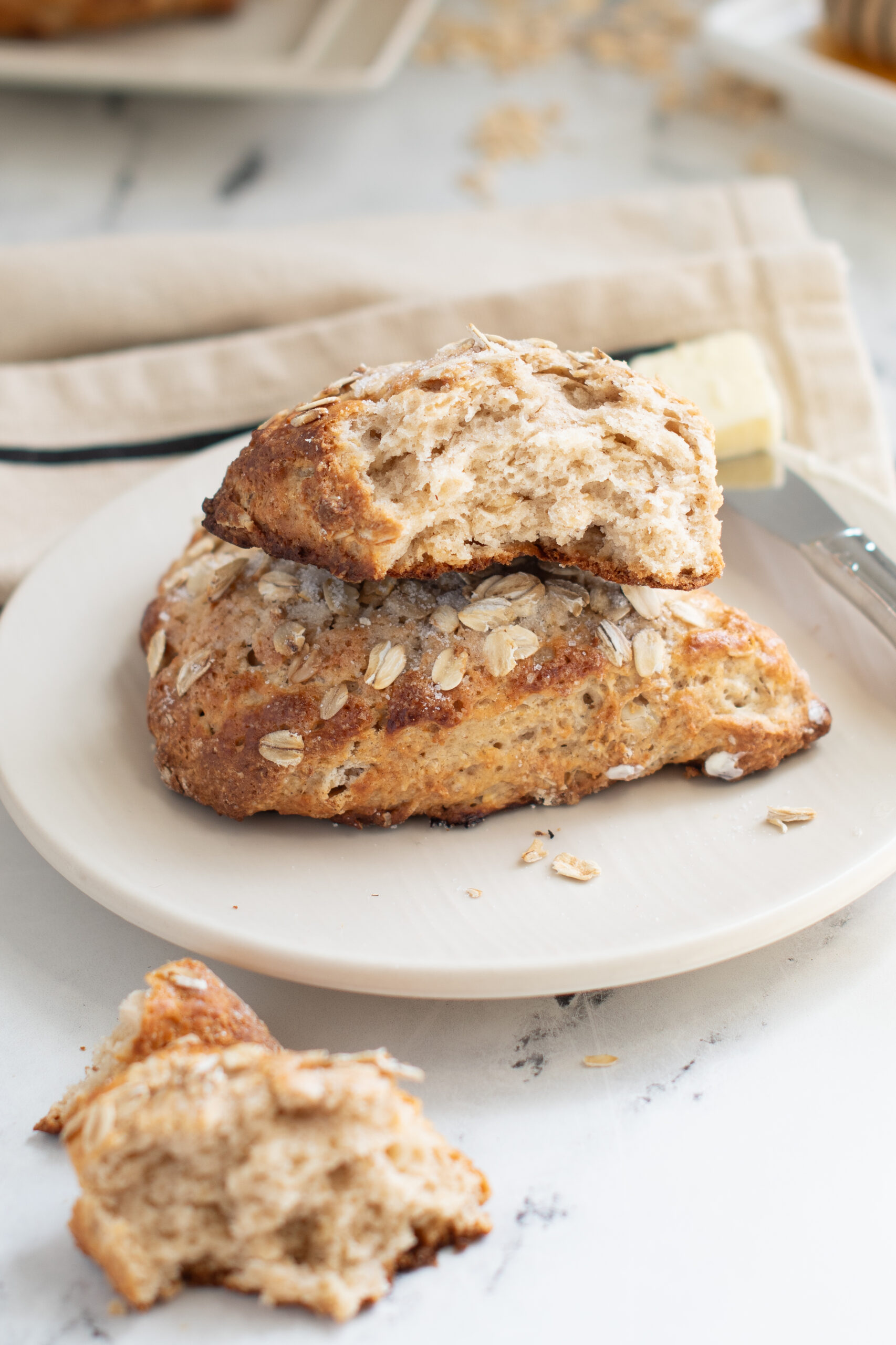 a whole and a half oatmeal scone on a white plate. 