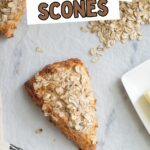 an oatmeal scone on parchment paper with oats scattered.