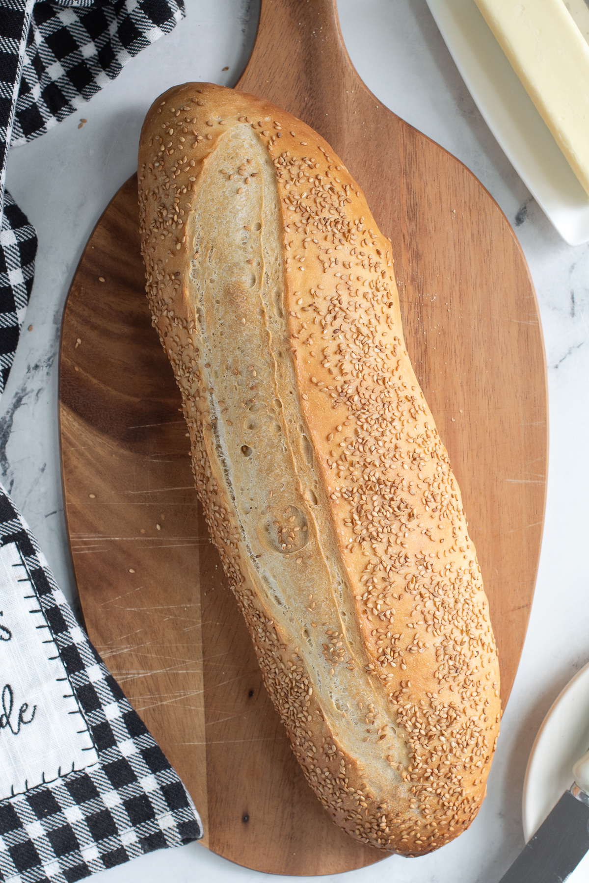 a loaf of seeded italian bread on a wood cutting board.