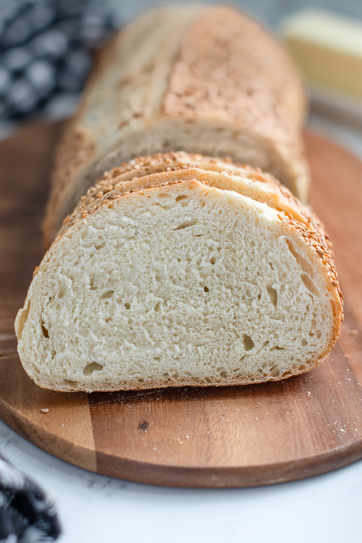 a closeup shot of a slice of italian bread on a cutting board.