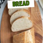 a slice loaf of italian bread on a wood cutting board.