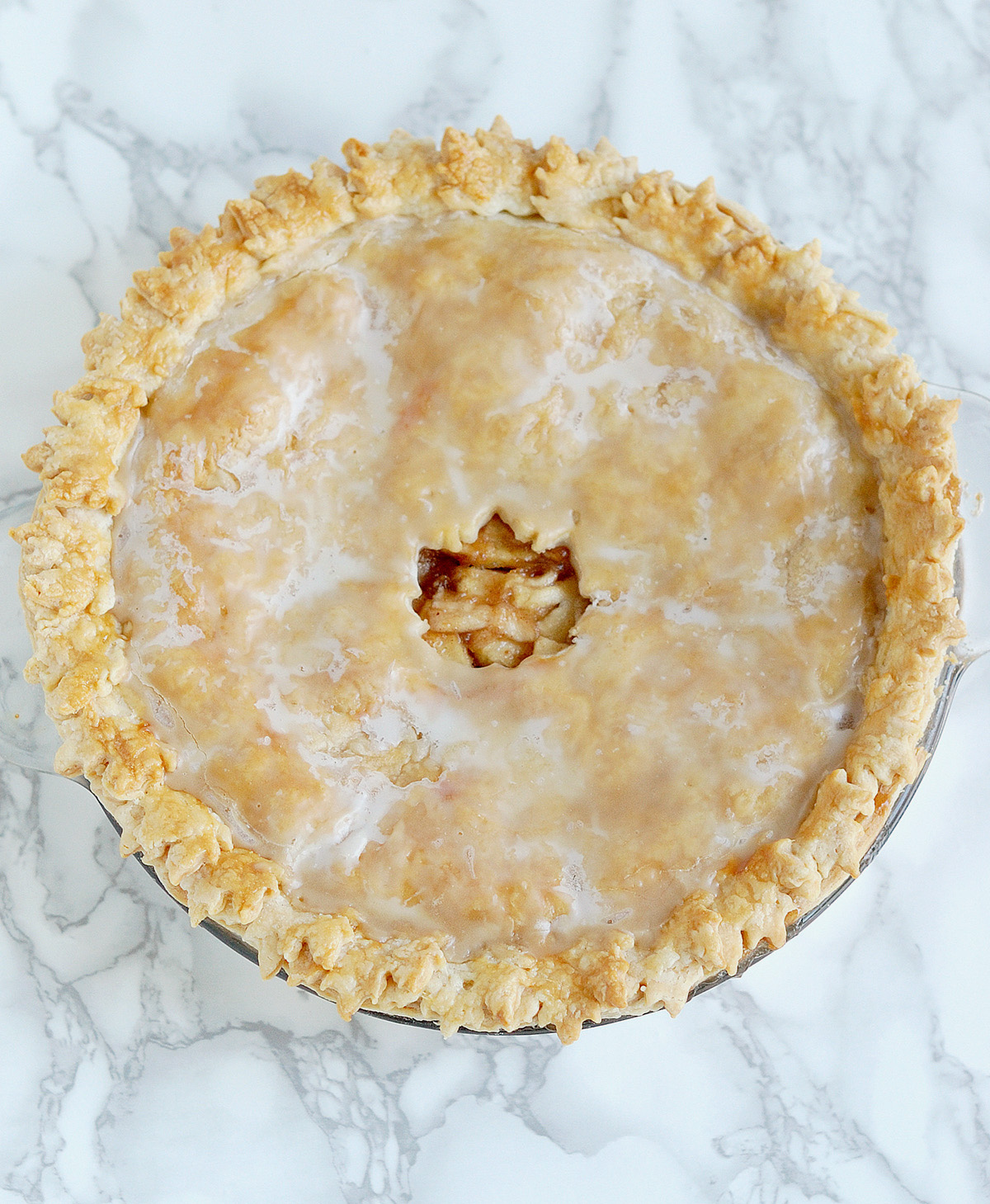 an apple maple pie on a marble table.