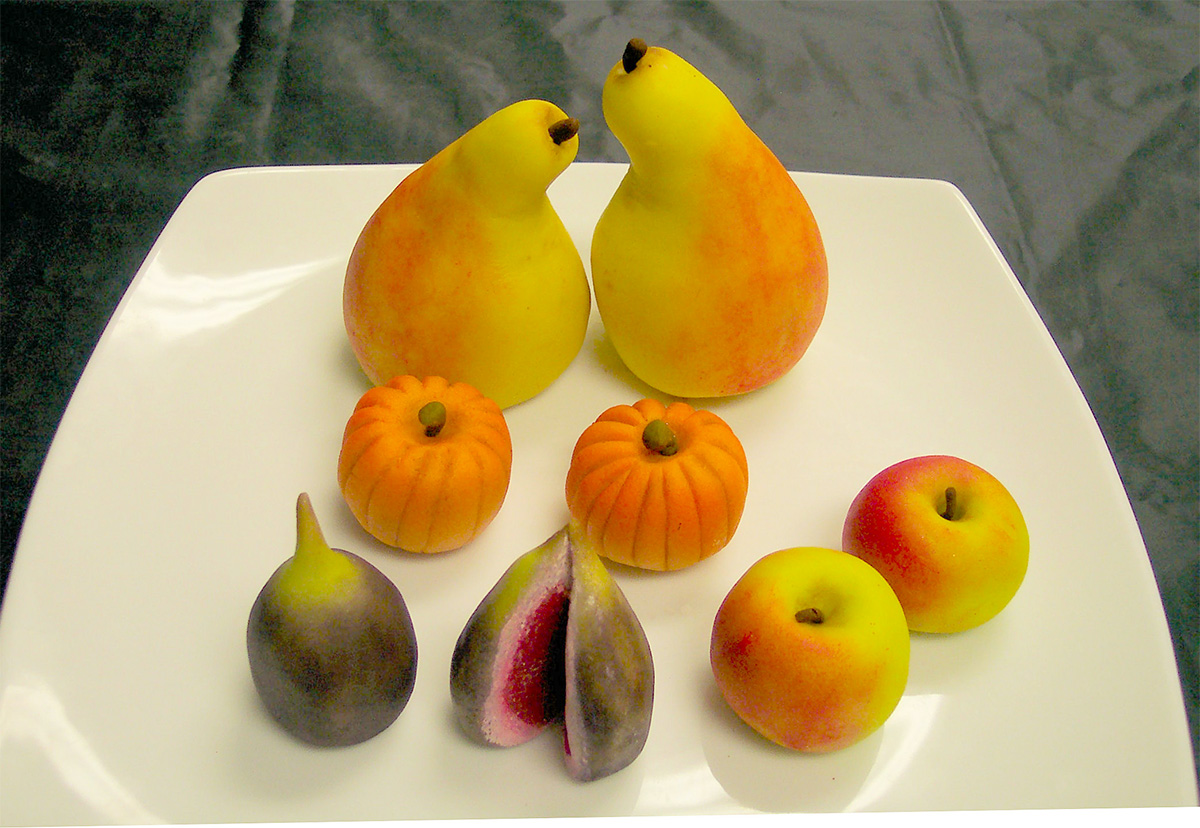 a tray of marzipan fruit including pears, pumpkins, apples and figs. 