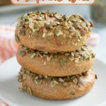 three sourdough pumpkin bagels on a white plate.