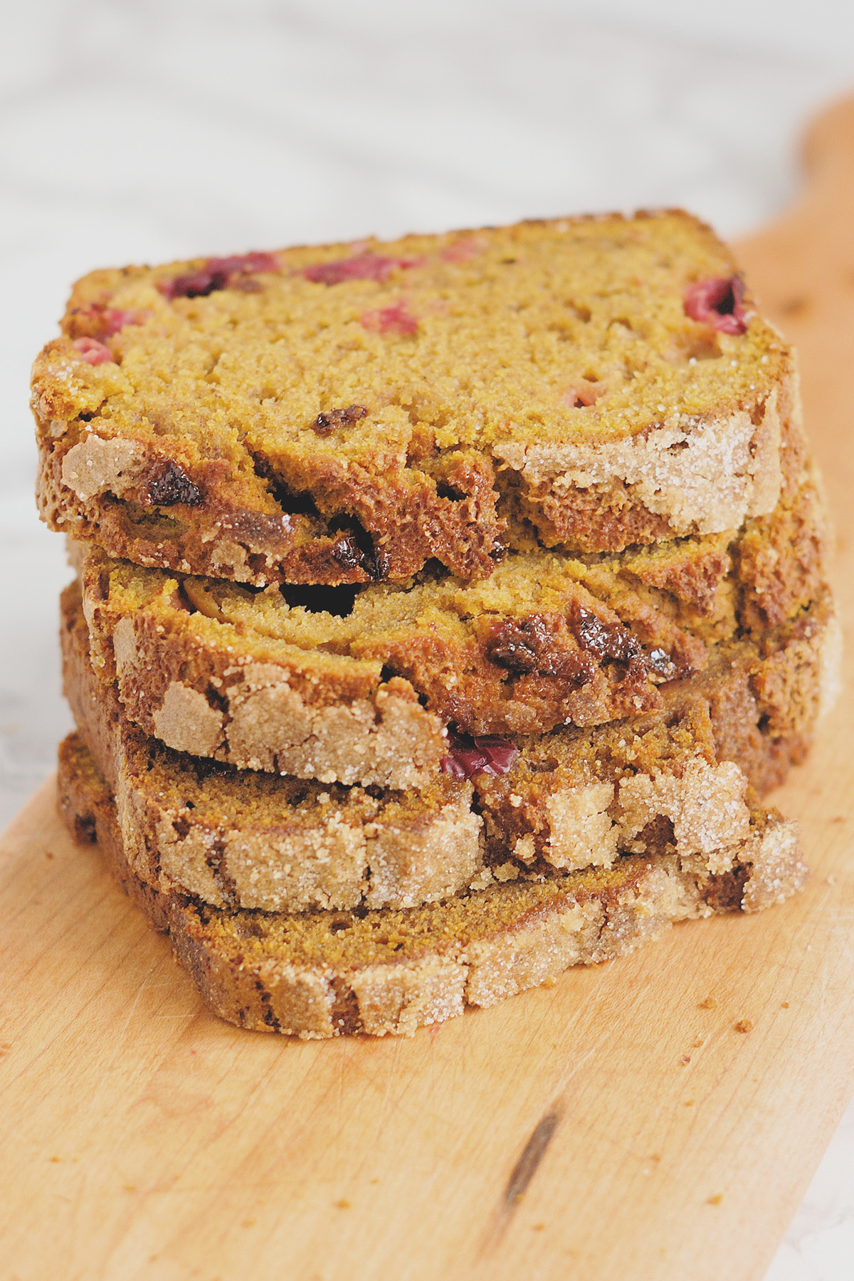 slices of sourdough discard pumpkin bread stacked on a cutting board.